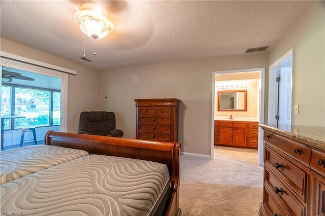 bedroom featuring sink, a textured ceiling, connected bathroom, and light carpet