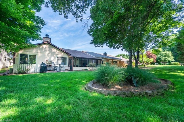 back of property featuring a yard and a sunroom