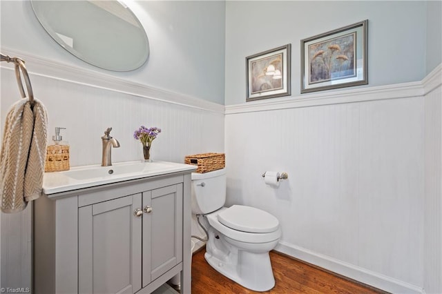 4919 Setter Ct, Jamestown, NC 27282 - half bathroom featuring a wainscoted wall, toilet, vanity, and wood finished floors