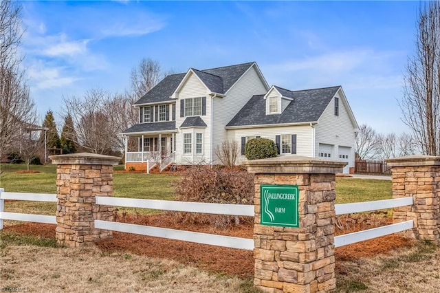 view of front of property featuring a garage, a front yard, and covered porch