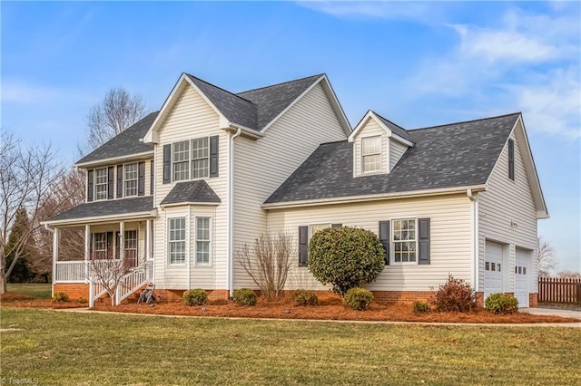 view of front of property featuring a garage, a front yard, and covered porch