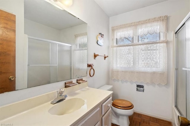 full bathroom featuring toilet, vanity, parquet flooring, and shower / bath combination with glass door