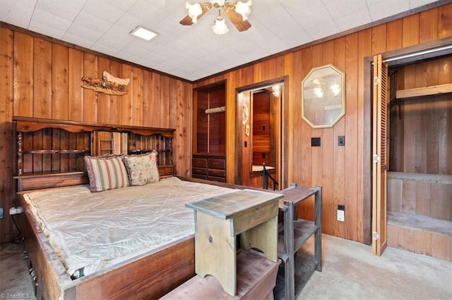 bedroom featuring ceiling fan, light colored carpet, wooden walls, and a closet