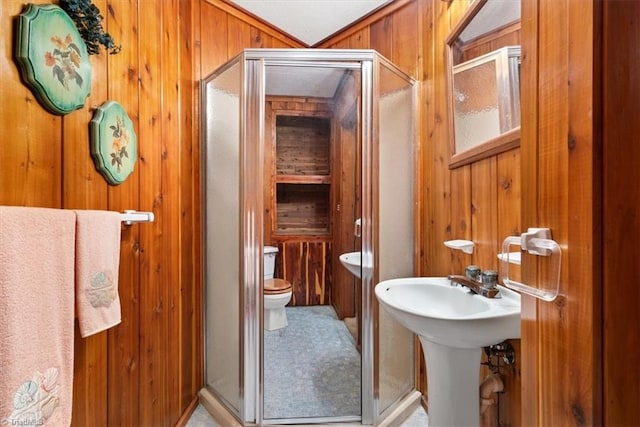 bathroom featuring wood walls, walk in shower, and toilet