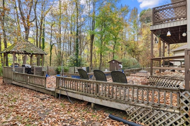 wooden deck featuring a storage unit and a gazebo