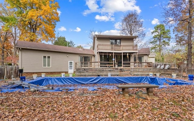 back of property with a balcony and a pool side deck