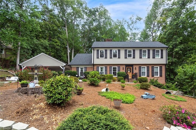 colonial inspired home featuring brick siding and a chimney