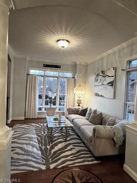 living room with decorative columns, hardwood / wood-style flooring, and crown molding