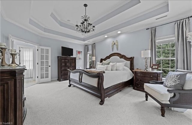 carpeted bedroom featuring a chandelier, a raised ceiling, and ornamental molding