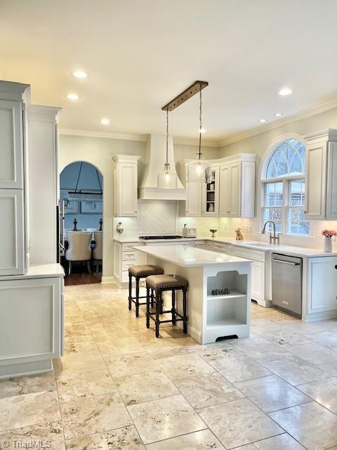 kitchen featuring a kitchen breakfast bar, pendant lighting, dishwasher, sink, and a kitchen island