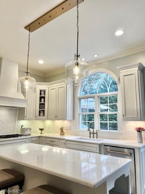 kitchen featuring sink, stainless steel appliances, custom exhaust hood, and pendant lighting