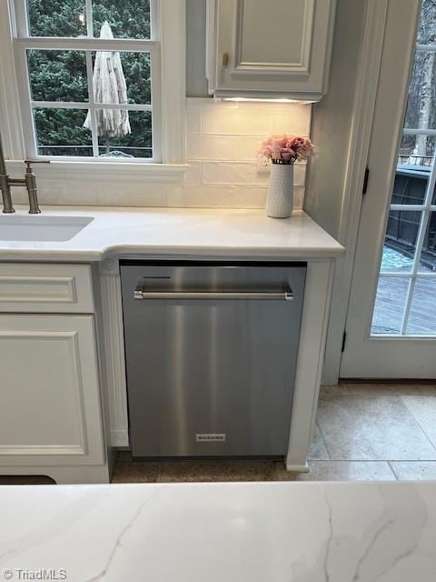 details with sink, gray cabinets, stainless steel dishwasher, and tasteful backsplash