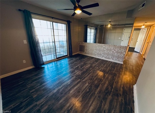 unfurnished living room featuring dark wood-type flooring and ceiling fan