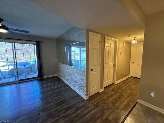 spare room featuring ceiling fan, dark wood-type flooring, and a textured ceiling