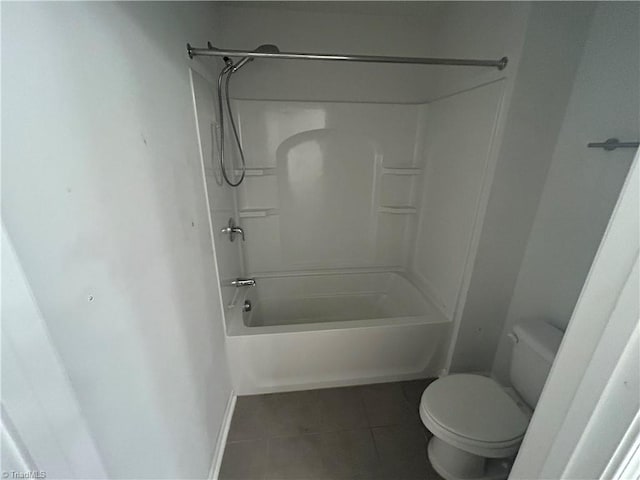 bathroom with tile patterned floors, baseboards, toilet, and washtub / shower combination