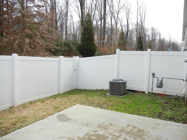 view of yard featuring a patio, central AC unit, and a fenced backyard