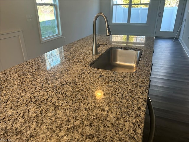 kitchen featuring dark stone countertops and a sink