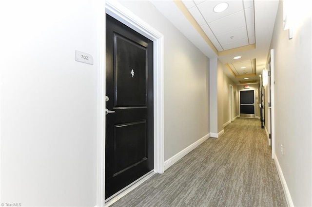 corridor with hardwood / wood-style floors and a paneled ceiling