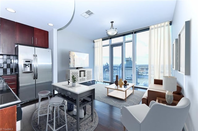 kitchen featuring stainless steel refrigerator with ice dispenser, a wall of windows, dark hardwood / wood-style floors, and tasteful backsplash