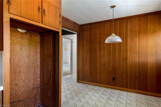 unfurnished dining area featuring wood walls