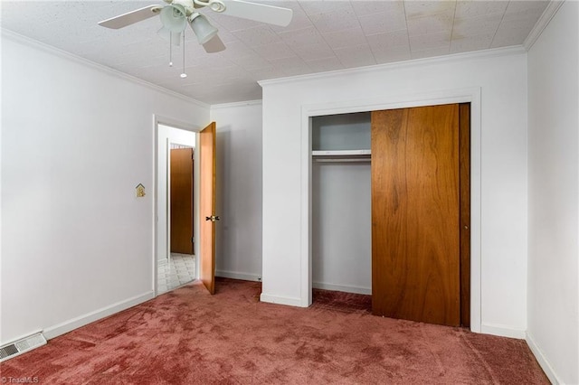 unfurnished bedroom featuring crown molding, carpet flooring, a closet, and ceiling fan