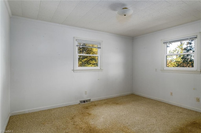 unfurnished room featuring crown molding, carpet flooring, and a wealth of natural light