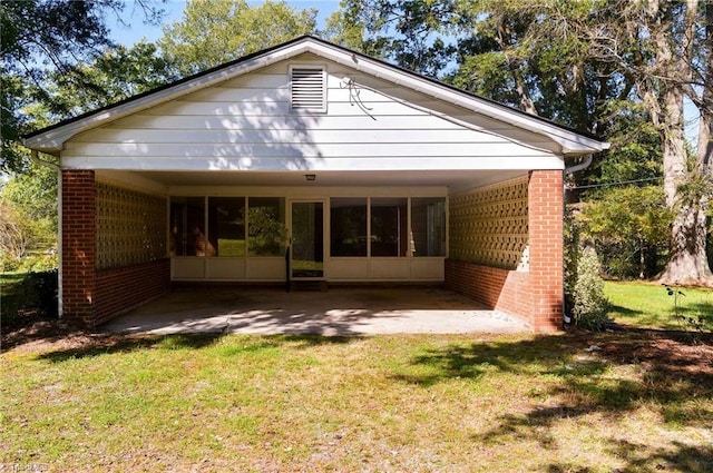 rear view of house with a lawn and a carport