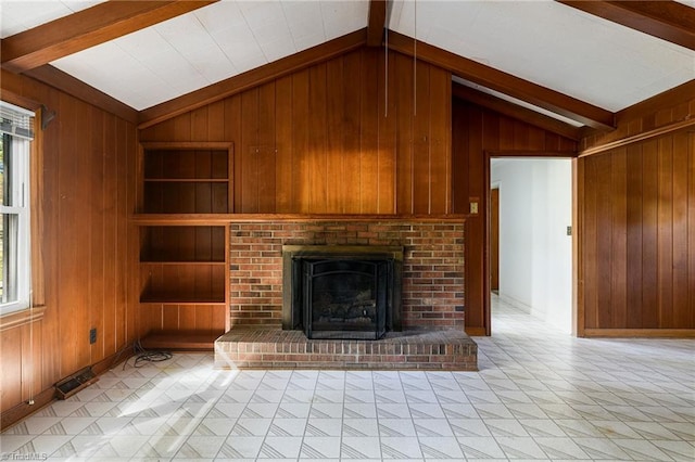 unfurnished living room with wooden walls, vaulted ceiling with beams, and a healthy amount of sunlight