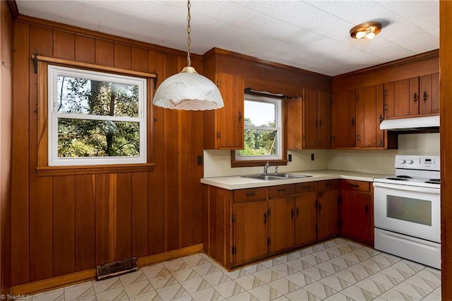 kitchen with white range with electric stovetop, sink, hanging light fixtures, and a wealth of natural light