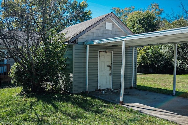 view of outdoor structure with a yard and a carport