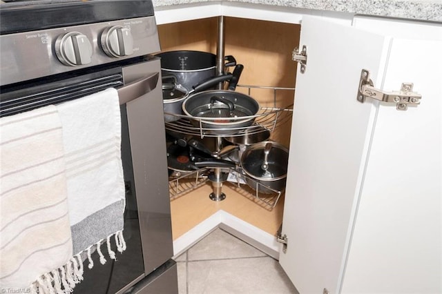 interior details featuring stainless steel stove and light tile patterned floors