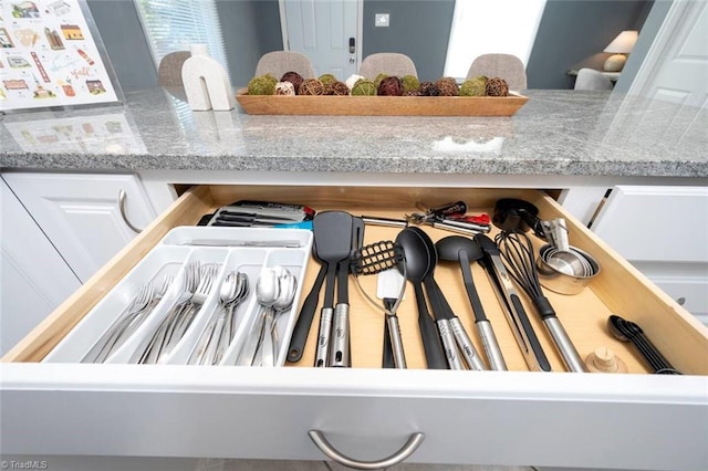 details featuring light stone countertops and white cabinets