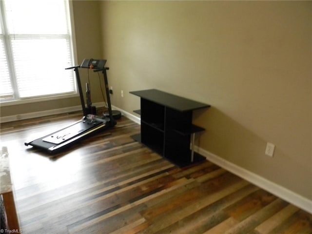 workout room featuring baseboards and dark wood-style flooring