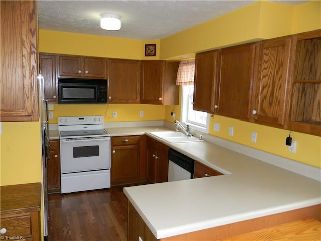 kitchen with brown cabinetry, light countertops, white appliances, and a sink