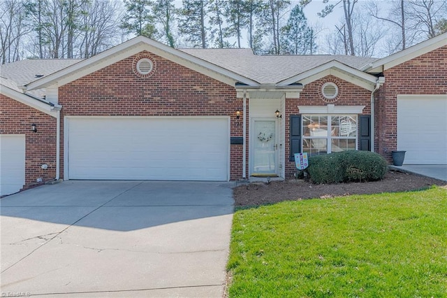 ranch-style house featuring a front yard, driveway, an attached garage, a shingled roof, and brick siding