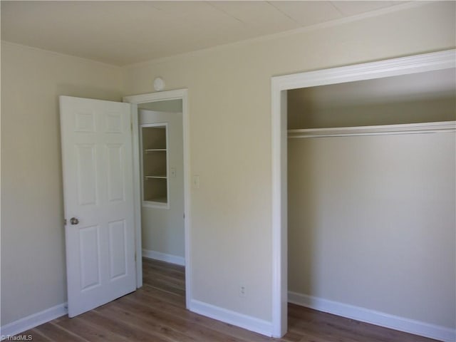 unfurnished bedroom featuring a closet and dark hardwood / wood-style floors