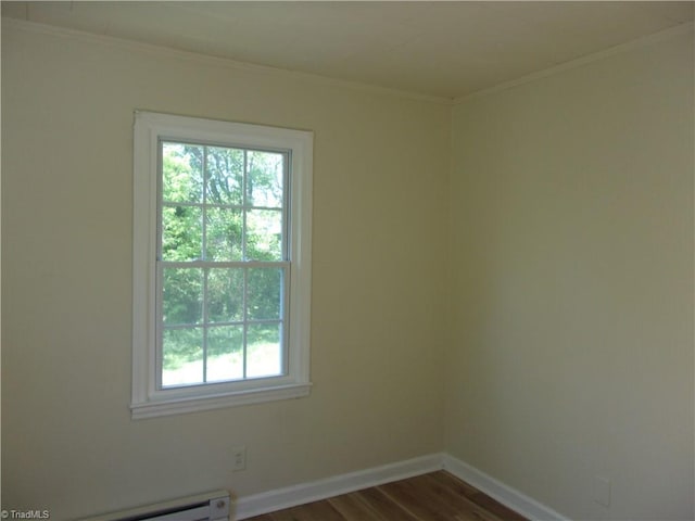 spare room featuring wood-type flooring and a baseboard radiator