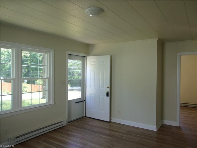 interior space featuring dark hardwood / wood-style floors, plenty of natural light, and a baseboard heating unit