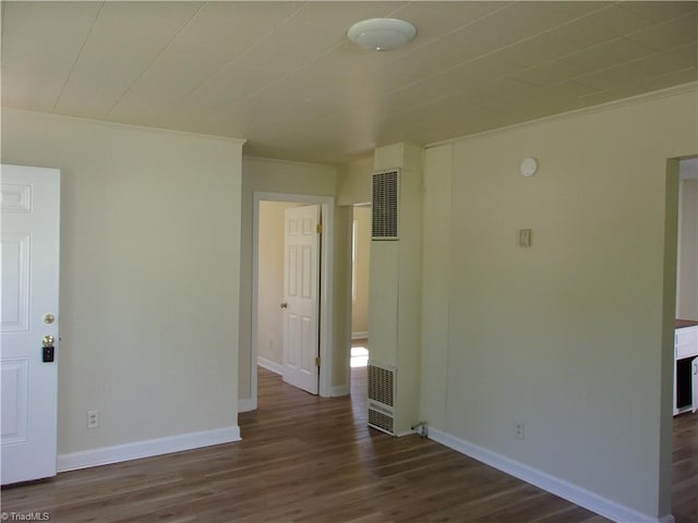 unfurnished room featuring ornamental molding and dark wood-type flooring