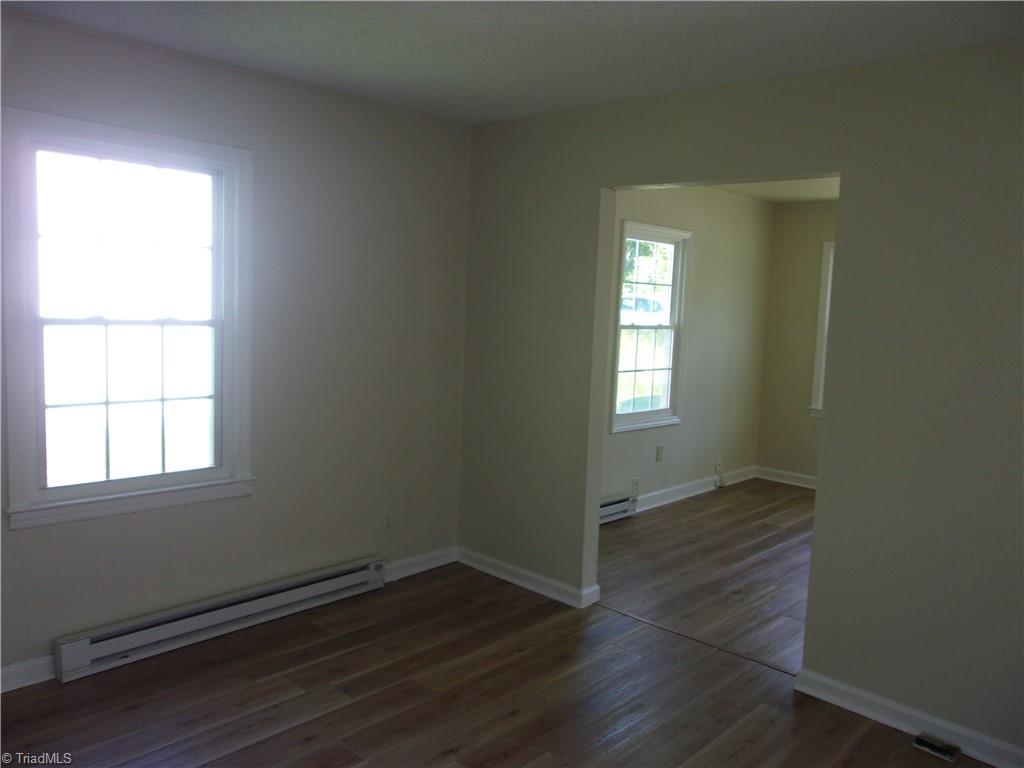 empty room featuring dark hardwood / wood-style flooring and baseboard heating