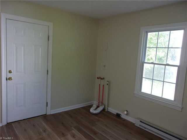 spare room with a baseboard radiator, hardwood / wood-style flooring, and a wealth of natural light