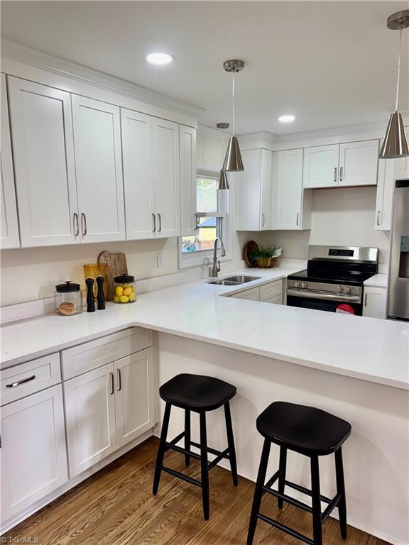 kitchen featuring a sink, a breakfast bar, white cabinetry, and stainless steel appliances