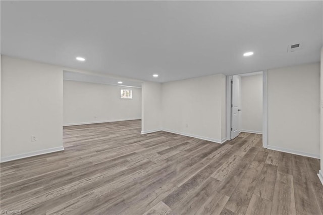 below grade area with visible vents, baseboards, recessed lighting, and wood finished floors