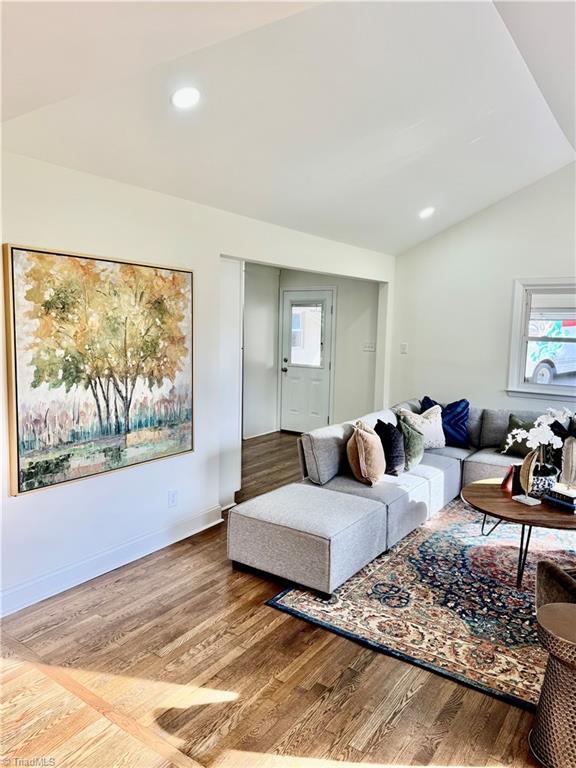 living area featuring recessed lighting, baseboards, wood finished floors, and vaulted ceiling