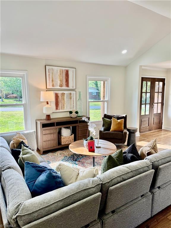 living area featuring recessed lighting, lofted ceiling, and wood finished floors