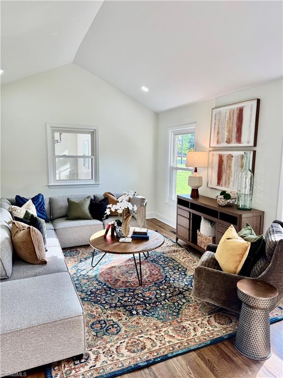 living room with wood finished floors and lofted ceiling