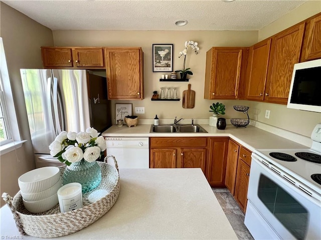 88 Tannenbaum Cir, Greensboro, NC 27410 - kitchen with white appliances, a sink, brown cabinets, and a textured ceiling