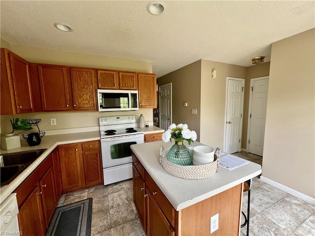 88 Tannenbaum Cir, Greensboro, NC 27410 - kitchen with white appliances, a sink, light countertops, a center island, and a textured ceiling