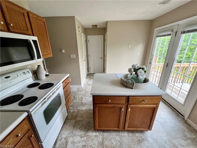 88 Tannenbaum Cir, Greensboro, NC 27410 - kitchen with white electric stove, baseboards, brown cabinetry, light countertops, and a textured ceiling