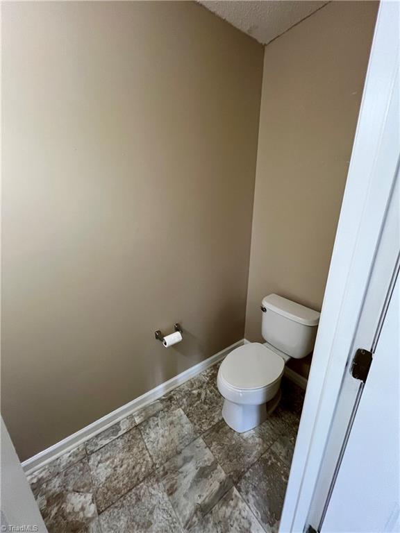 88 Tannenbaum Cir, Greensboro, NC 27410 - bathroom featuring toilet, baseboards, and a textured ceiling